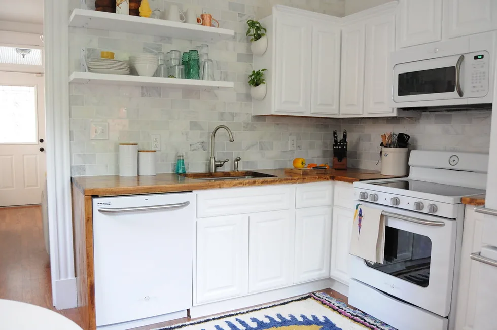 Bright kitchen with a white dishwasher, stove, and microwave, the appliances we repair